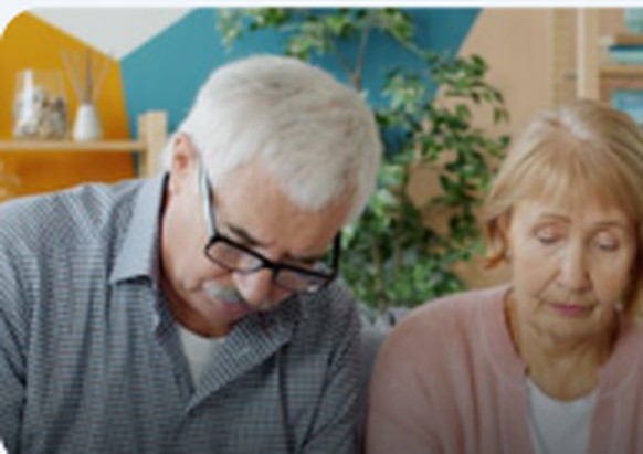 Senior couple reading Medicare information at home
