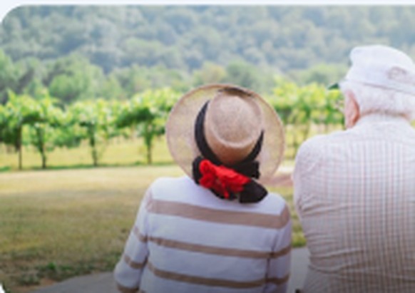Senior couple in sun hats sitting outdoors